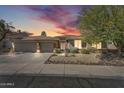 Charming home exterior showcasing a well-manicured front yard and attached three-car garage, enhanced by a stunning sky at dusk at 7686 S Myrtle Ave, Tempe, AZ 85284