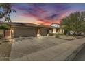 Charming home exterior showcasing a well-manicured front yard and attached three-car garage, enhanced by a stunning sky at dusk at 7686 S Myrtle Ave, Tempe, AZ 85284