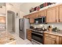 Well-equipped kitchen featuring stainless steel appliances, wooden cabinetry, and a stylish tile backsplash at 7703 E Sayan St, Mesa, AZ 85207