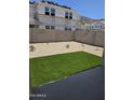 View of artificial turf area in backyard with block wall and rock features at 9831 S 11Th St, Phoenix, AZ 85042