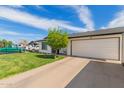 Inviting exterior showcasing a manicured lawn, white siding, and an attached two-car garage at 113 N Ridge Cir, Mesa, AZ 85203