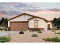 Charming single-story home with a two-car garage, tile roof, and desert landscaping at dusk at 1417 W Hopi Dr, Coolidge, AZ 85128