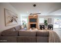 Bright living room featuring a fireplace, modern lighting, and a comfortable sectional sofa at 15440 N 54Th St, Scottsdale, AZ 85254