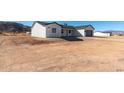 Attractive single-story home featuring white stucco siding, dark trim and a gray garage door at 16560 N Slate Ln, Maricopa, AZ 85139