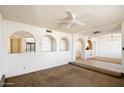 Open-concept living room with archways, neutral carpet, and tile flooring, creating a warm and inviting space at 17037 E El Pueblo Blvd, Fountain Hills, AZ 85268