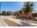 Inviting exterior view of a home showcasing a well-kept yard and desert landscaping in a quiet neighborhood at 17577 W Desert Bloom St, Goodyear, AZ 85338