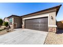 Home exterior showcasing the two-car garage, desert landscaping, and stone accents at 17588 W Maricopa St, Goodyear, AZ 85338