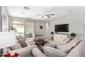 Bright living room with neutral tones, a ceiling fan, and sliding door access to the patio at 17588 W Maricopa St, Goodyear, AZ 85338