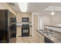 Traditional kitchen featuring a black refrigerator, oven and microwave with light wood cabinets at 18416 N Cave Creek Rd # 2053, Phoenix, AZ 85032