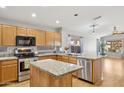 Well-lit kitchen with stainless steel appliances, granite counters, and a functional island at 19595 N 107Th Dr, Sun City, AZ 85373