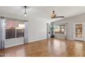 Bright living room with hardwood floors, vaulted ceiling, and large windows at 19595 N 107Th Dr, Sun City, AZ 85373