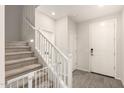 Inviting entryway featuring modern gray wood-look floors and a staircase with white railings at 22962 N 182Nd Ln, Surprise, AZ 85387