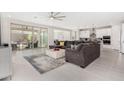 Bright open-concept living room featuring tiled floors, a modern ceiling fan and access to the outdoor patio at 25913 W Sands Dr, Buckeye, AZ 85396