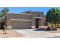 Single-story home featuring neutral stucco, a two-car garage, and front yard desert landscaping at 2605 N 115Th Dr, Avondale, AZ 85392