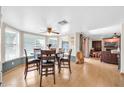 Well-lit dining room featuring wood floors, a ceiling fan, and large windows at 2919 W Kerry Ln, Phoenix, AZ 85027