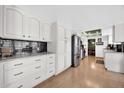 Galley kitchen with white cabinets, black backsplash, and stainless steel appliances at 2919 W Kerry Ln, Phoenix, AZ 85027