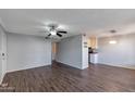 Spacious living room featuring wood-look floors, a ceiling fan, and a modern light fixture over the dining area at 3500 N Hayden Rd # 2109, Scottsdale, AZ 85251