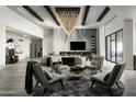 Modern living room featuring soaring ceilings, designer lighting, a decorative accent wall, and comfortable seating at 37975 N 98Th Pl, Scottsdale, AZ 85262