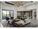 Bright living room features an elegant chandelier, a modern sofa, and access to outdoor spaces at 37975 N 98Th Pl, Scottsdale, AZ 85262