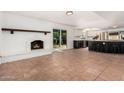 Open living area with a white brick fireplace, tile flooring, and easy access to the kitchen at 3927 W Phelps Rd, Phoenix, AZ 85053