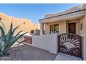 Southwestern-style home featuring desert landscaping, decorative metal gate, and covered entry at 4309 S Priceless View Dr, Gold Canyon, AZ 85118