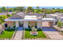 Stunning modern home featuring stone accents, a covered driveway, and professionally landscaped front yard at 4704 N 40Th Pl, Phoenix, AZ 85018
