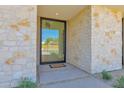 Close-up of the modern front door featuring a glass panel and stone exterior at 4704 N 40Th Pl, Phoenix, AZ 85018