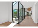 Bright hallway with wood floors and a large glass wall leading to a private courtyard at 4704 N 40Th Pl, Phoenix, AZ 85018