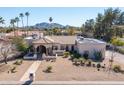 Expansive desert landscaping defines this single-story home with a large, flat roof and mountain views at 5345 E Mercer Ln, Scottsdale, AZ 85254