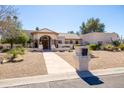 Charming single-story home with manicured desert landscaping and a stone walkway leading to the front door at 5345 E Mercer Ln, Scottsdale, AZ 85254