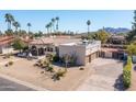 Desert landscaping and three-car garage highlight this single-story home in a lush, palm-lined neighborhood at 5345 E Mercer Ln, Scottsdale, AZ 85254