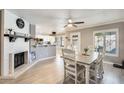 Open-concept dining area with updated lighting, neutral paint, and view of kitchen and fireplace at 6938 W Wescott Dr, Glendale, AZ 85308