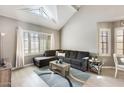 Bright living room with vaulted ceilings, skylight, cozy sectional, and large windows at 6938 W Wescott Dr, Glendale, AZ 85308