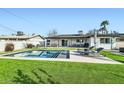 Backyard pool area with lounge chairs, a spacious patio, lush green grass, and inviting outdoor seating at 7333 E Palm Ln, Scottsdale, AZ 85257