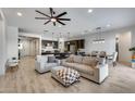 Open-concept living area with tile floors, comfortable seating, a ceiling fan, and natural light at 7694 W Desert Spoon Dr, Peoria, AZ 85383