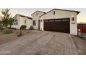 Inviting home features a paver driveway, desert landscaping, and a two-car garage with modern lighting at 8009 W Northview Ave, Glendale, AZ 85303