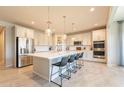 Bright, modern kitchen featuring an island with seating, stainless steel appliances, and pendant lighting at 9937 E Harvest Rd, Florence, AZ 85132