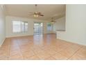 Open concept living space with neutral tile flooring, ceiling fans, and sliding glass doors at 1052 W Paseo Way, Tempe, AZ 85283