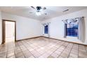 Neutral bedroom with tile floors, windows, and a ceiling fan at 1235 E Clearview Dr, Casa Grande, AZ 85122