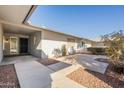 A covered entry area with a concrete patio and minimal, drought tolerant landscaping at 12946 W Maplewood Dr, Sun City West, AZ 85375