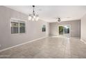 Bright, open living area with tile flooring, modern light fixtures, and sliding glass doors at 141 W Jamaica Pl, Casa Grande, AZ 85122