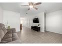 Bright living room featuring tile floors, ceiling fan, contemporary furniture, and a mounted television at 2277 S Apache Dr # 7, Apache Junction, AZ 85120