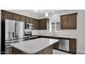 Stylish kitchen with stainless steel appliances, island, dark wood cabinets, and tile flooring at 2296 S 235Th Dr, Buckeye, AZ 85326
