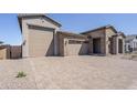 Spacious home featuring a three-car garage and a brick-paved driveway at 23146 E Nightingale Rd, Queen Creek, AZ 85142