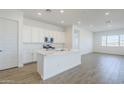 Bright, open kitchen with white cabinets, quartz countertops, and stainless steel appliances at 23146 E Nightingale Rd, Queen Creek, AZ 85142