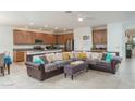 Open-concept living room featuring tile flooring, kitchen with stainless steel appliances, and a modern ceiling fan at 25330 N 134Th Dr, Peoria, AZ 85383