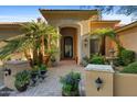 Elegant front entrance with decorative archway, potted plants, and a wrought iron gate at 2799 E Jade Pl, Chandler, AZ 85286