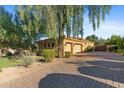 Spacious three-car garage with a long, paved driveway and mature landscaping at 2799 E Jade Pl, Chandler, AZ 85286