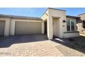 Attractive one-story home with a neutral-toned exterior, a paved driveway, and low maintenance front yard landscaping at 357 E Las Puertas Ln, Queen Creek, AZ 85140