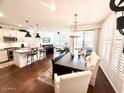 Bright, open-concept living space with hardwood floors, modern lighting, and a dining area with large windows at 357 E Las Puertas Ln, Queen Creek, AZ 85140